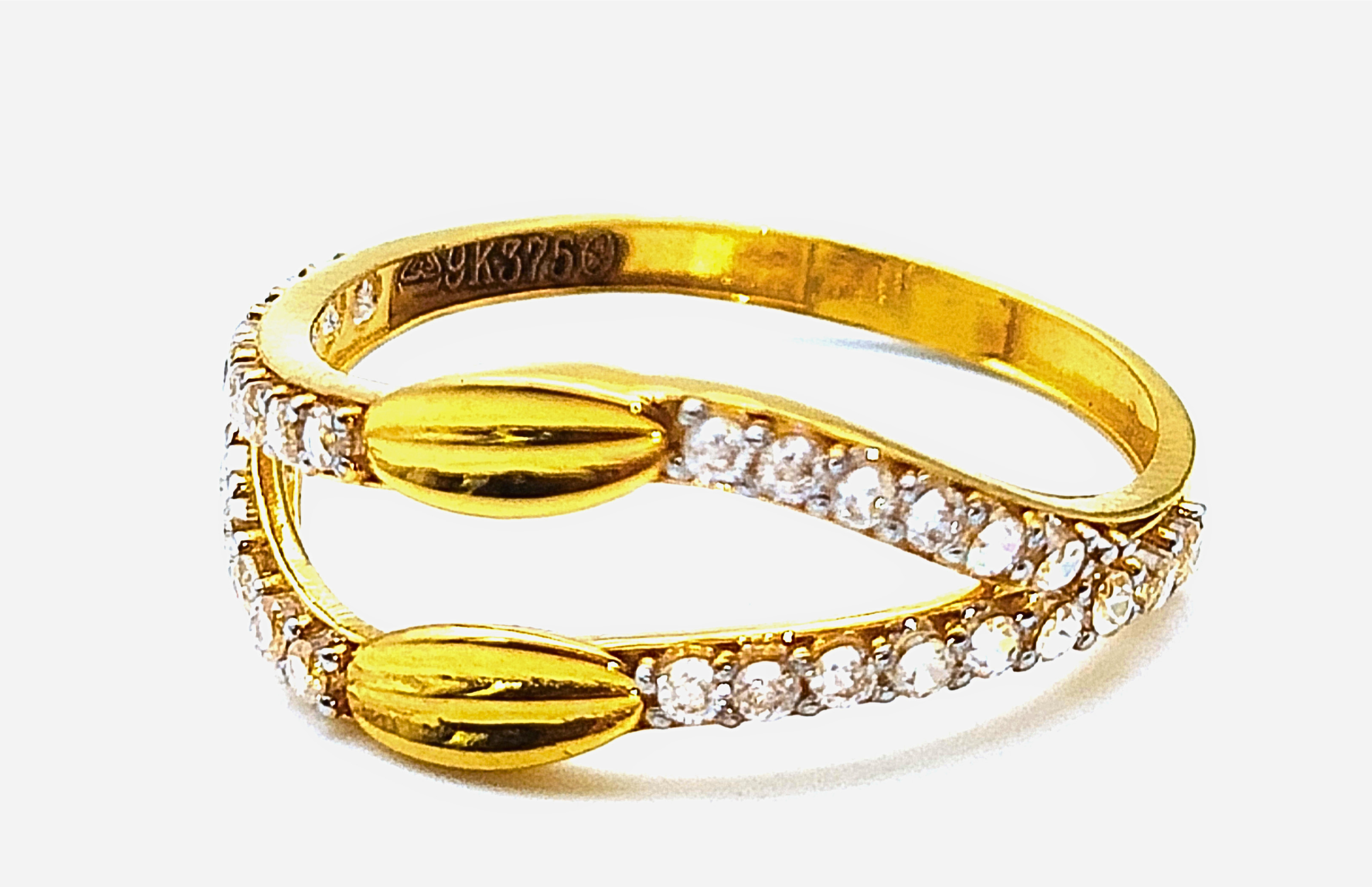 9k yellow gold bypass ring featuring cz stones and textured gold leaf accents with bis hallmark huid stamp