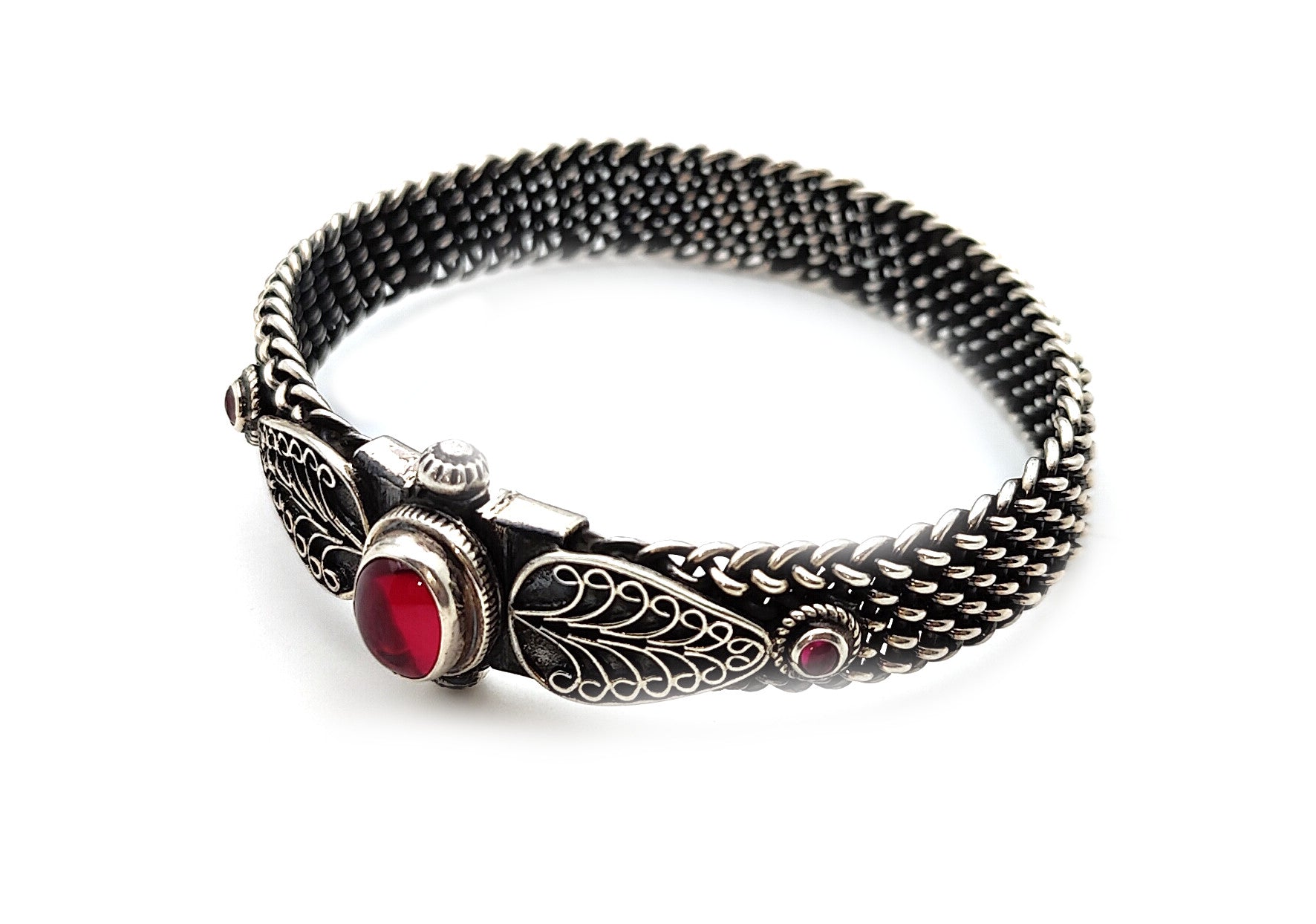 Close-up image of a 925 silver bangle adorned with rubies, showcasing its intricate wire design.